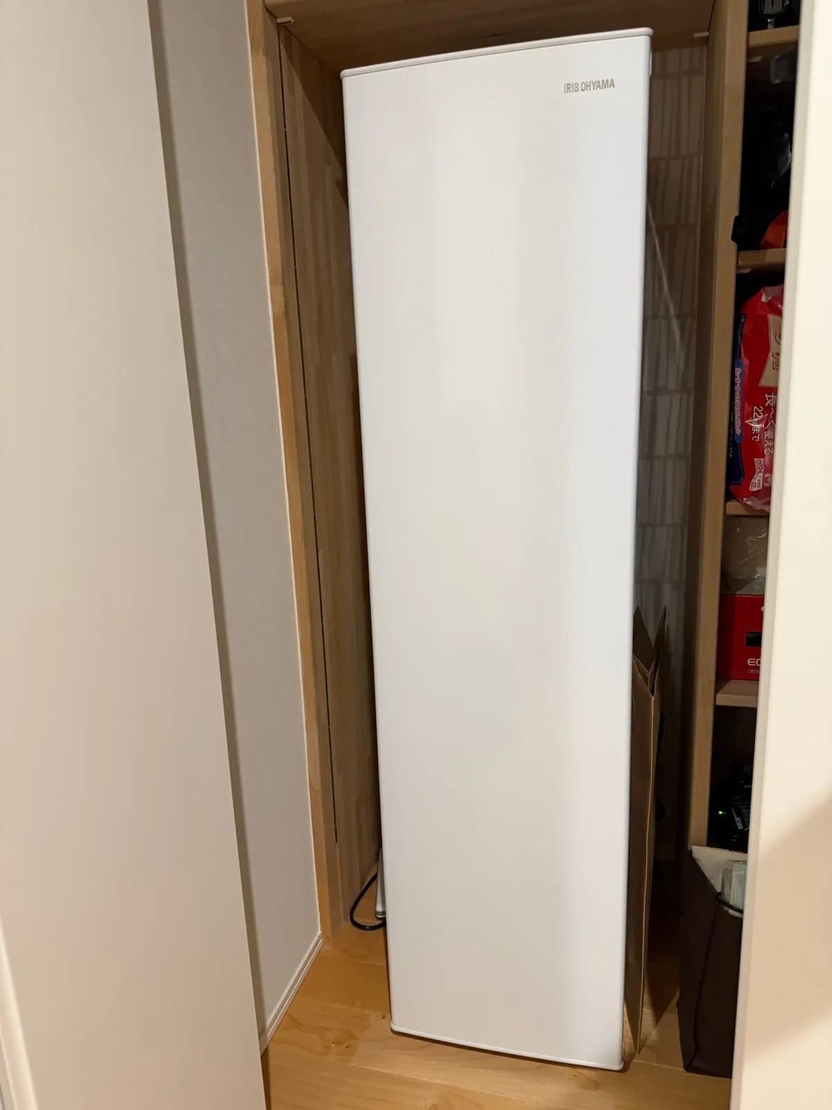 アイリスオーヤマの縦型冷凍庫。パントリーの棚の脇にぴったり収まっている